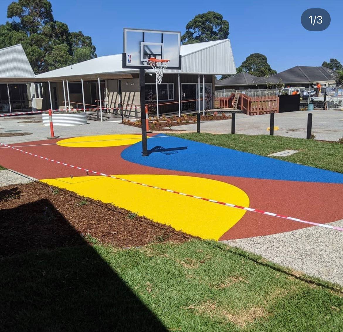 Colourful red, yellow and blue wet pour rubber outdoor basketball half-court